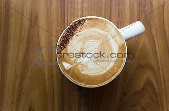 Leaf shaped coffee milk foam in white ceramic cup