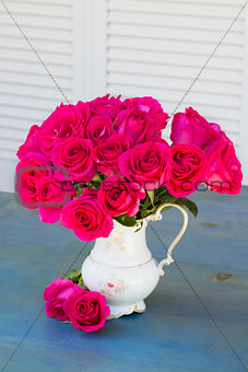 Mauve roses in vase on blue table