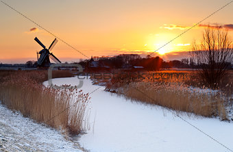 sunrise by windmill in winter