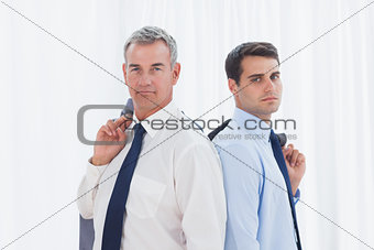 Serious businessmen posing back to back together