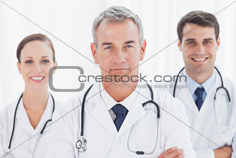 Cheerful doctors posing together crossing arms