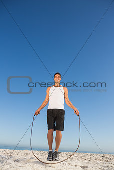 Cheerful sporty man jumping rope