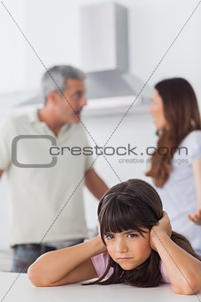 Angry couple having dispute in front of their daughter blocking her ears