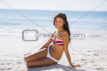 Sexy tanned woman in bikini smiling at camera