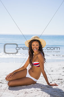 Attractive young tanned woman wearing straw hat posing