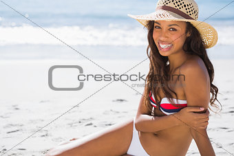 Cheerful young tanned woman wearing straw hat posing