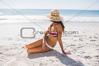 Young sexy woman wearing straw hat taking sun