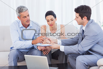 Salesman giving contract to client and his wife
