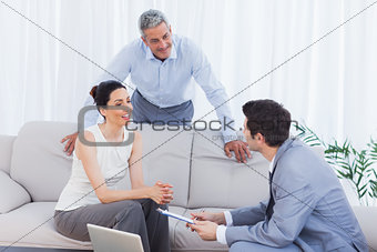 Salesman talking with customers on couch