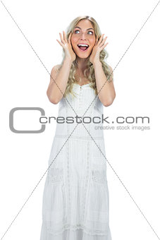 Surprised gorgeous model in white dress posing