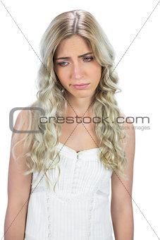 Unhappy seductive model in white dress posing
