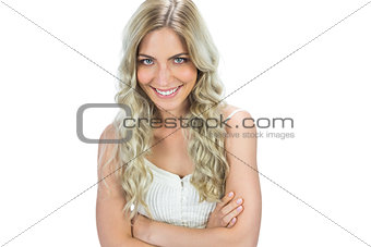Cheerful seductive model in white dress posing crossing arms
