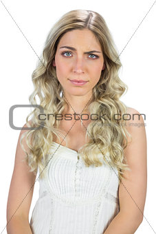 Blond model in white dress rising her eyebrow