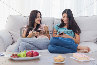 Friends sitting using their smartphones
