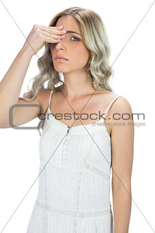 Attractive blond model having headache touching her forehead