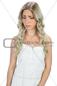 Unhappy curly haired blonde posing