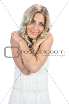 Curly haired blonde hugging herself