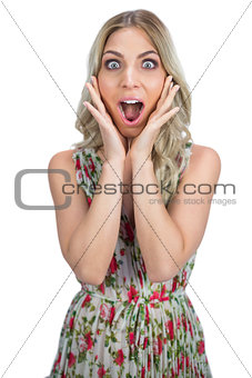 Surprised pretty blonde wearing flowered dress posing