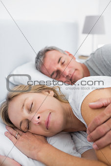 Peaceful couple sleeping and spooning in bed