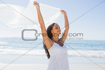 Beautiful brunette in white sun dress holding sarong