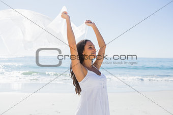 Pretty brunette in white sun dress holding sarong
