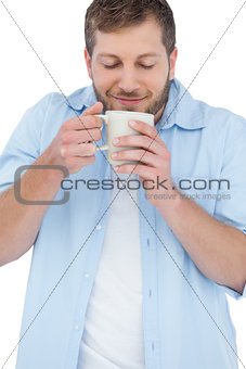 Casual model having coffee and smelling it