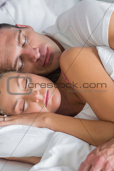 Attractive couple sleeping and spooning in bed