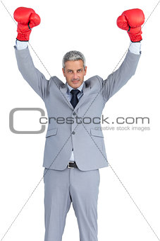 Businessman posing with red boxing gloves hands up