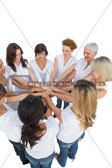 Happy female models joining hands in a circle