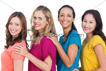 Smiling models posing with colorful t shirts