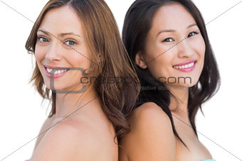 Smiling beautiful nude models posing back to back