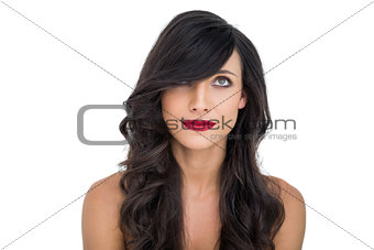 Pretty dark haired woman posing with red lips looking up