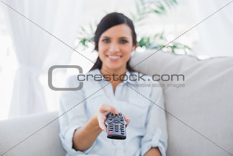 Cheerful attractive brunette changing tv channels