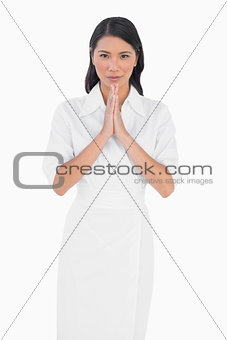 Elegant dark haired model with white dress joining hands