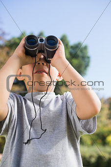 Boy looking through binoculars to the sky
