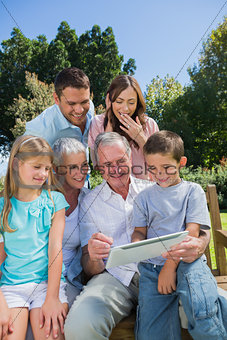 Multi generation family with a tablet pc sitting in park