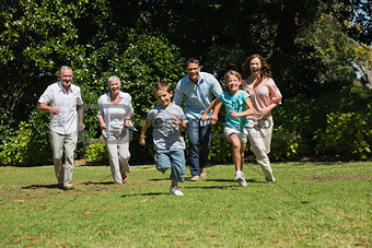Happy multi generation family running towards camera