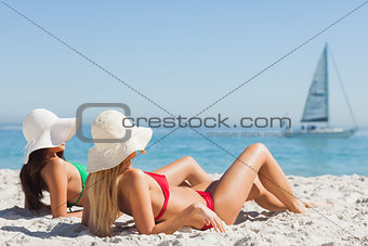 Attractive women in bikinis tanning