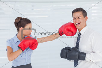 Businesswoman punching her colleague while boxing together