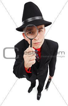 Serious detective looking through magnifying glass