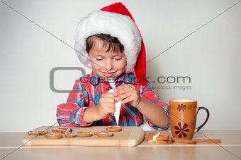 Llittle boy decorating the cookies