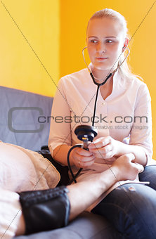 Nurse measures the patient blood pressure