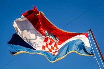 Croatian Flag Waving on a Pole over Beautiful Blue Sky in Omis, 