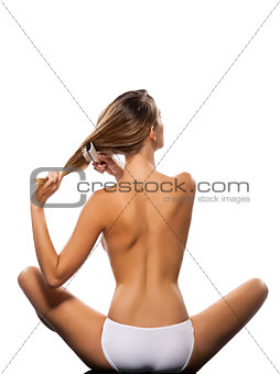Topless woman brushing her hair