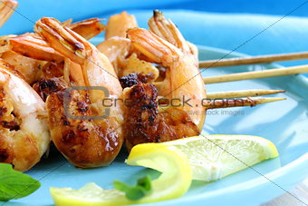 shrimp grilled on wooden skewers with lemon and basil
