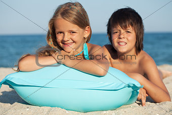 Kids with inflatable raft at the beach