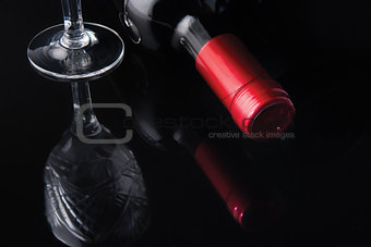 bottle of wine and a glass on a black background