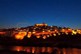 Walled town illuminated at night