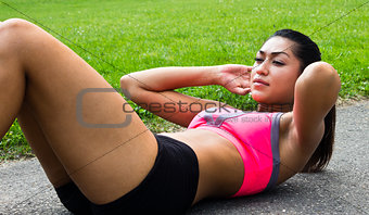 Fit young woman doing sit-ups outdoors