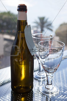 Wine bottle with a two glasses on the outdoor background